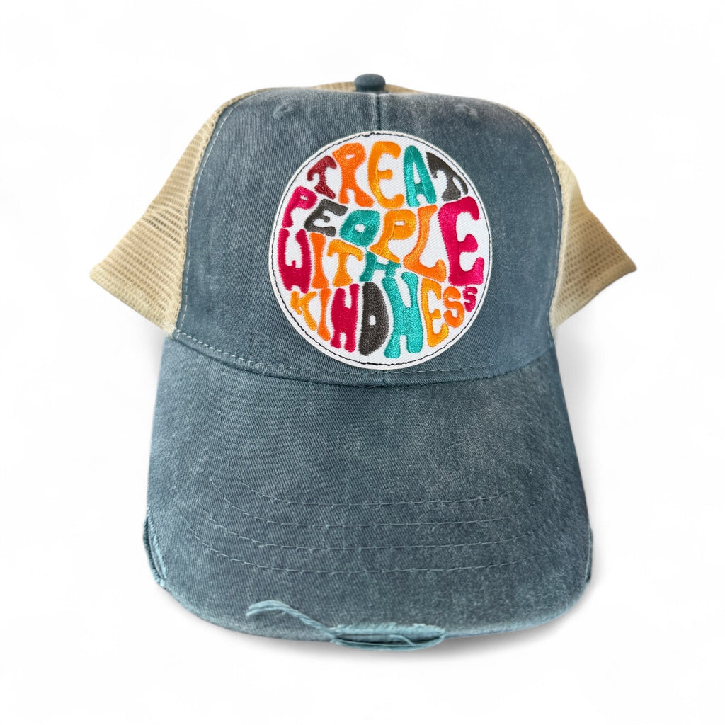 Blue denim cap with colorful kindness themed text design on a white background